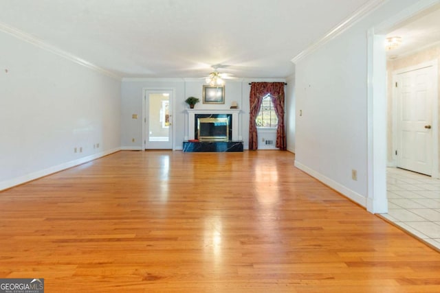 unfurnished living room featuring baseboards, a high end fireplace, ceiling fan, light wood-style floors, and crown molding