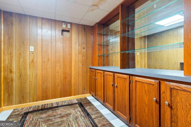 bar featuring a paneled ceiling and wood walls