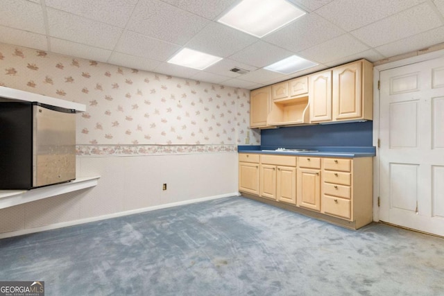 kitchen featuring carpet flooring, baseboards, light brown cabinetry, and wallpapered walls