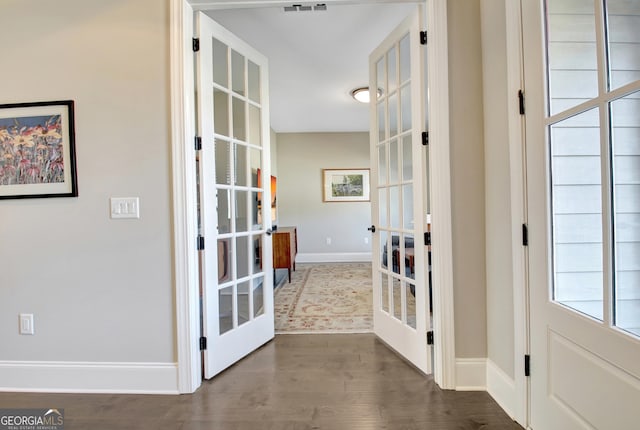 doorway to outside featuring french doors, baseboards, and dark wood-style flooring