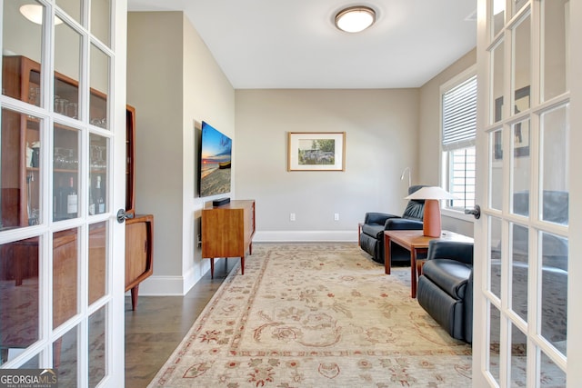 sitting room featuring wood finished floors, french doors, and baseboards