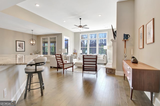 living area with recessed lighting, a ceiling fan, dark wood-style flooring, and baseboards