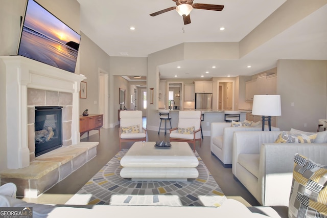 living area with recessed lighting, ceiling fan, and a tiled fireplace