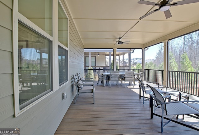 wooden deck with outdoor dining area and a ceiling fan