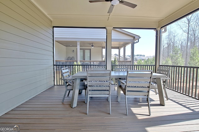 wooden terrace featuring outdoor dining area and a ceiling fan