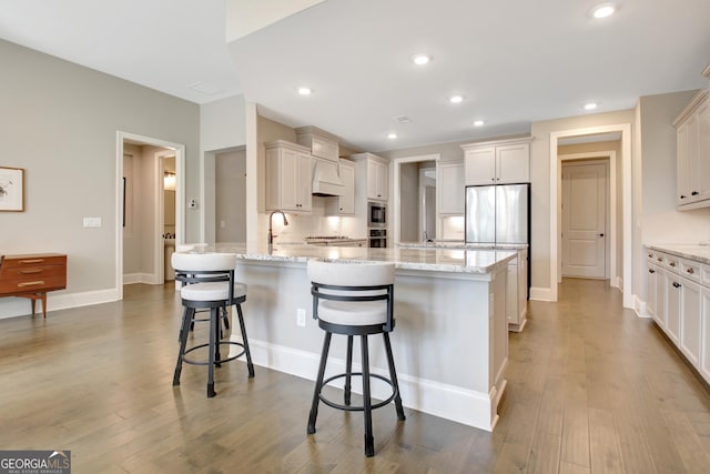 kitchen featuring a peninsula, a kitchen breakfast bar, light stone counters, and dark wood-type flooring