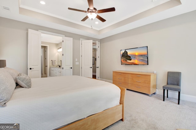 bedroom featuring a tray ceiling, baseboards, visible vents, and light carpet