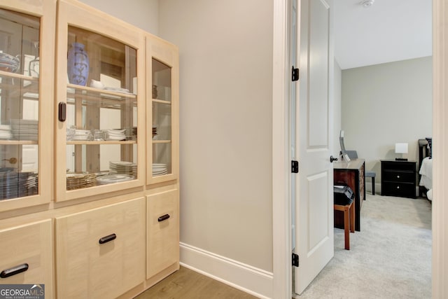 hallway featuring light wood-type flooring and baseboards