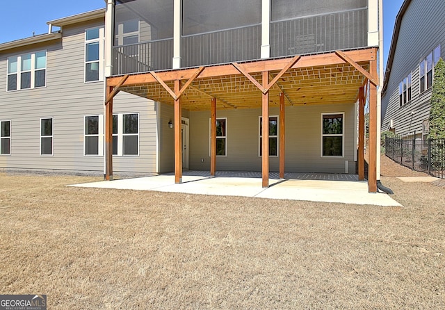 rear view of property featuring a yard, a patio, and fence