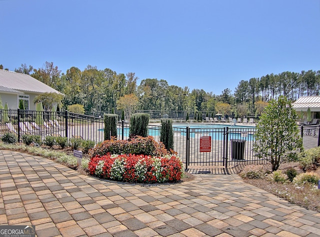 view of gate with a community pool and fence