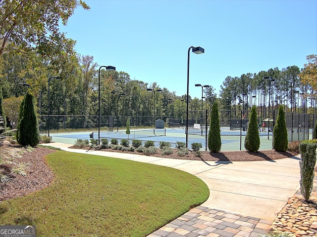 view of sport court with community basketball court, fence, and a lawn