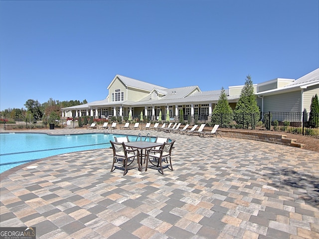 community pool featuring a patio area and fence