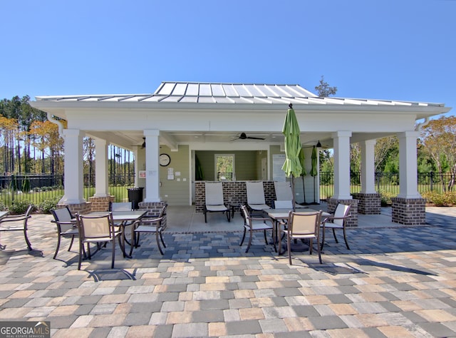 view of patio featuring a gazebo, outdoor dining space, and fence