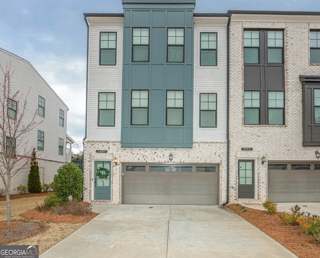 multi unit property with brick siding, concrete driveway, and a garage