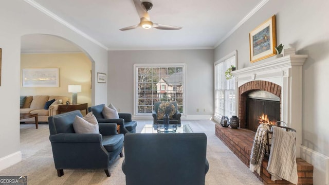 living room with a ceiling fan, carpet, arched walkways, and baseboards