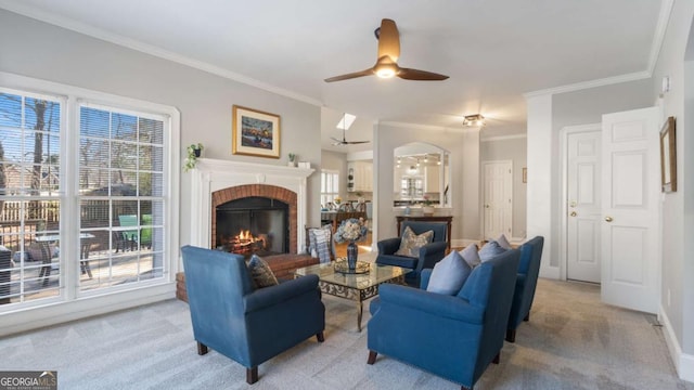 carpeted living room with a fireplace, plenty of natural light, a ceiling fan, and baseboards