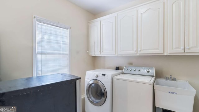 washroom with a sink, cabinet space, and washing machine and dryer