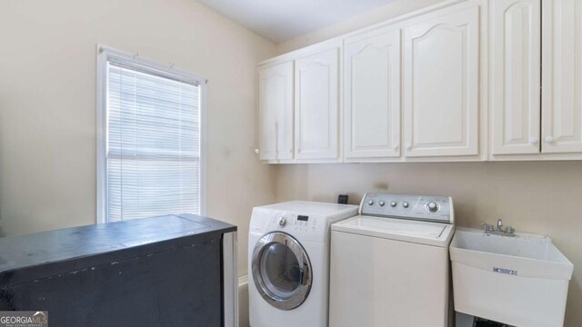 laundry room featuring cabinet space, a sink, and independent washer and dryer