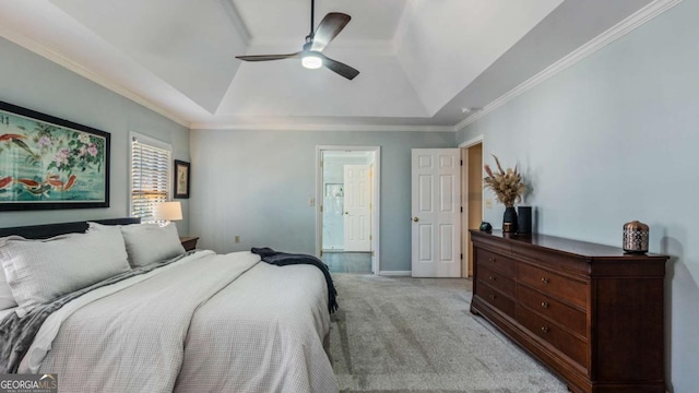 bedroom featuring ceiling fan, a tray ceiling, light colored carpet, and ornamental molding