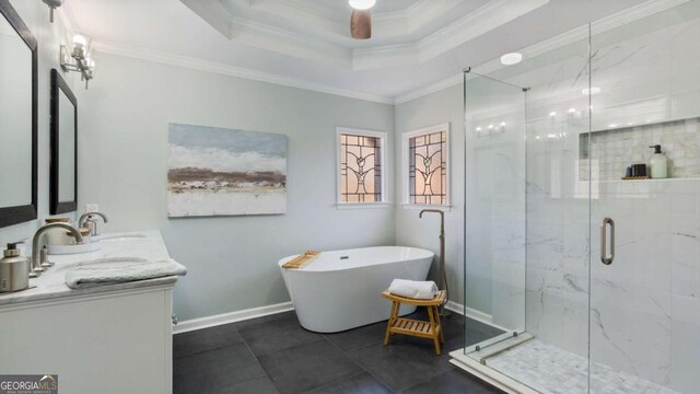 bathroom featuring a freestanding tub, a tray ceiling, crown molding, a marble finish shower, and baseboards