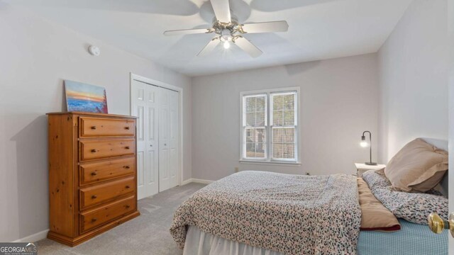 bedroom featuring light carpet, baseboards, a closet, and ceiling fan