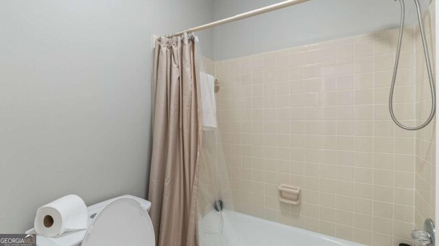 full bath with toilet and shower / bath combo with shower curtain