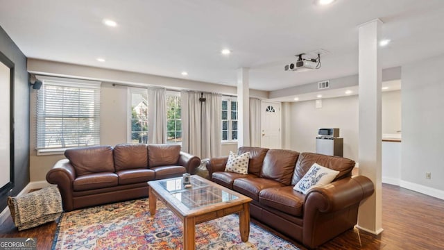 living room with recessed lighting, visible vents, baseboards, and wood finished floors