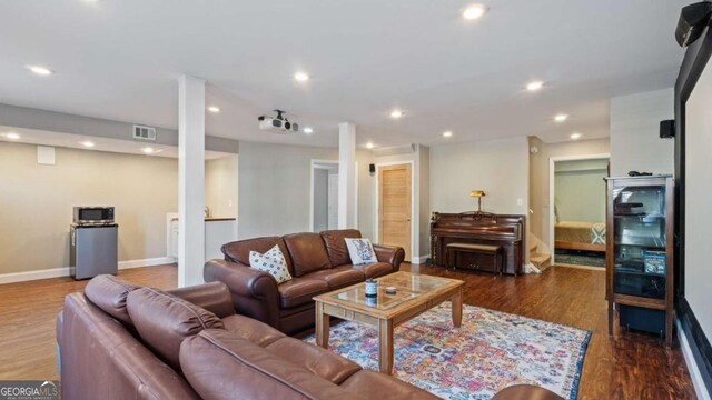 living room with baseboards, visible vents, wood finished floors, and recessed lighting