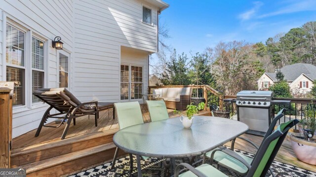 wooden deck featuring a grill and outdoor dining space