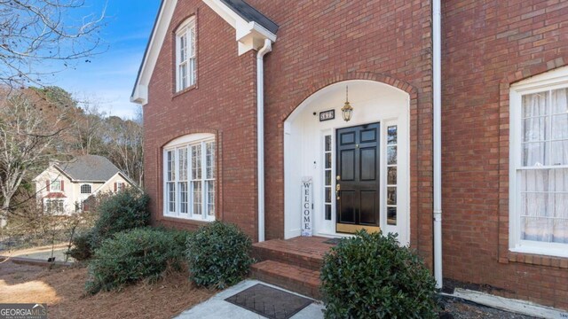 doorway to property featuring brick siding