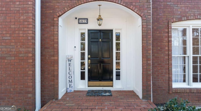 doorway to property featuring brick siding