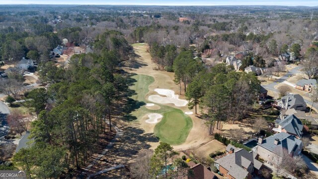 bird's eye view with golf course view and a wooded view