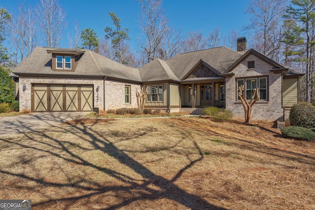 view of front of house featuring brick siding, an attached garage, a chimney, and roof with shingles