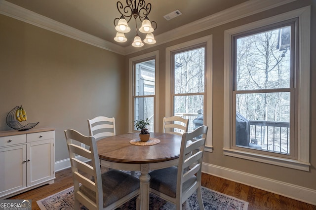 dining area with visible vents, crown molding, baseboards, an inviting chandelier, and dark wood-style flooring