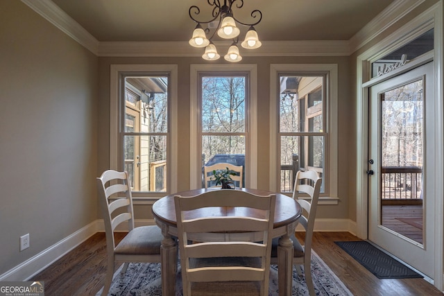 dining room featuring a chandelier, dark wood finished floors, baseboards, and ornamental molding