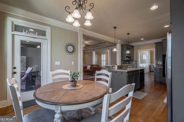 dining space with recessed lighting, wood finished floors, and ornamental molding