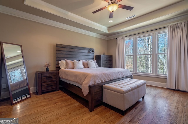 bedroom with multiple windows, wood finished floors, and visible vents