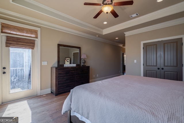 bedroom with visible vents, recessed lighting, wood finished floors, a raised ceiling, and access to outside