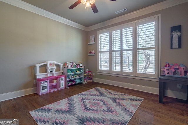 game room featuring visible vents, baseboards, ornamental molding, wood finished floors, and a ceiling fan