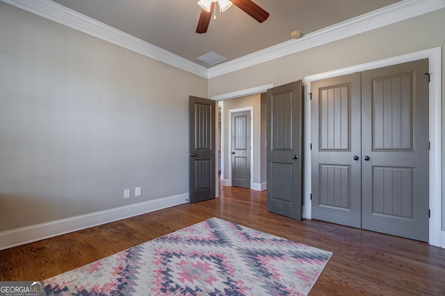 bedroom with ornamental molding, a ceiling fan, wood finished floors, a closet, and baseboards