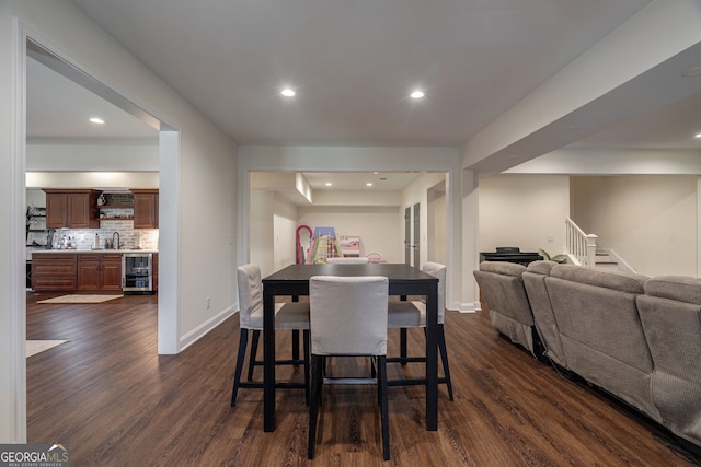 dining area featuring dark wood finished floors, stairs, beverage cooler, and baseboards