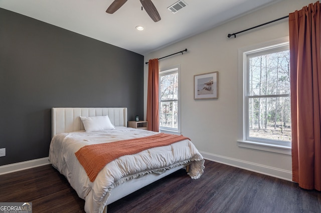 bedroom featuring visible vents, baseboards, and wood finished floors