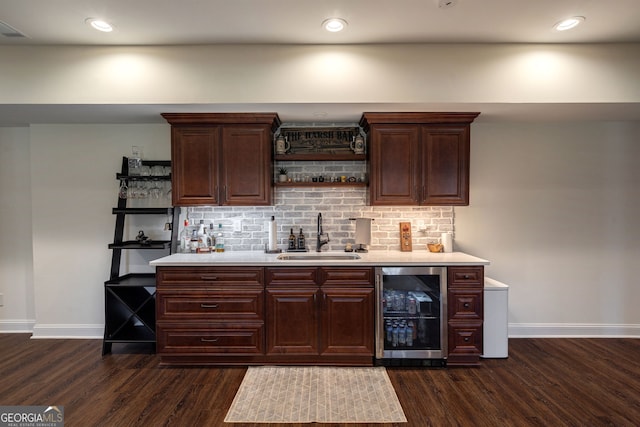 bar featuring dark wood-style flooring, a sink, indoor wet bar, wine cooler, and backsplash