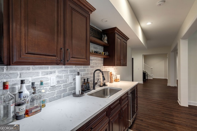 kitchen featuring dark wood finished floors, open shelves, a sink, dark brown cabinets, and tasteful backsplash