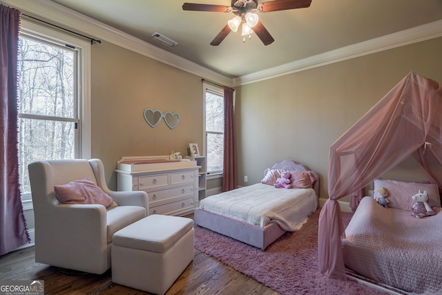 bedroom featuring multiple windows, crown molding, and wood finished floors