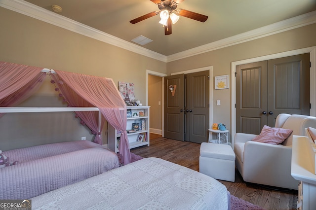 bedroom featuring visible vents, crown molding, baseboards, wood finished floors, and a ceiling fan