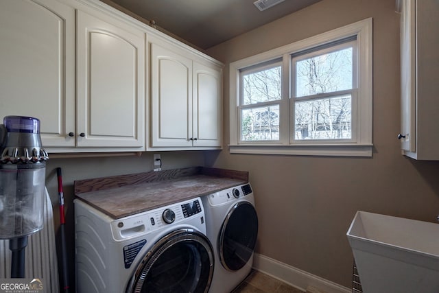 clothes washing area featuring visible vents, baseboards, cabinet space, independent washer and dryer, and a sink