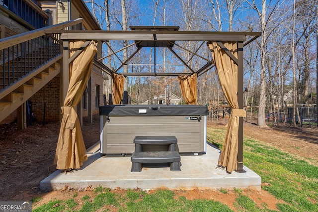 view of patio featuring a hot tub and fence