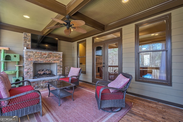 view of patio / terrace featuring an outdoor living space with a fireplace, a ceiling fan, and french doors