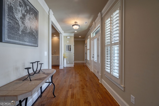 interior space with wood finished floors, baseboards, visible vents, recessed lighting, and crown molding